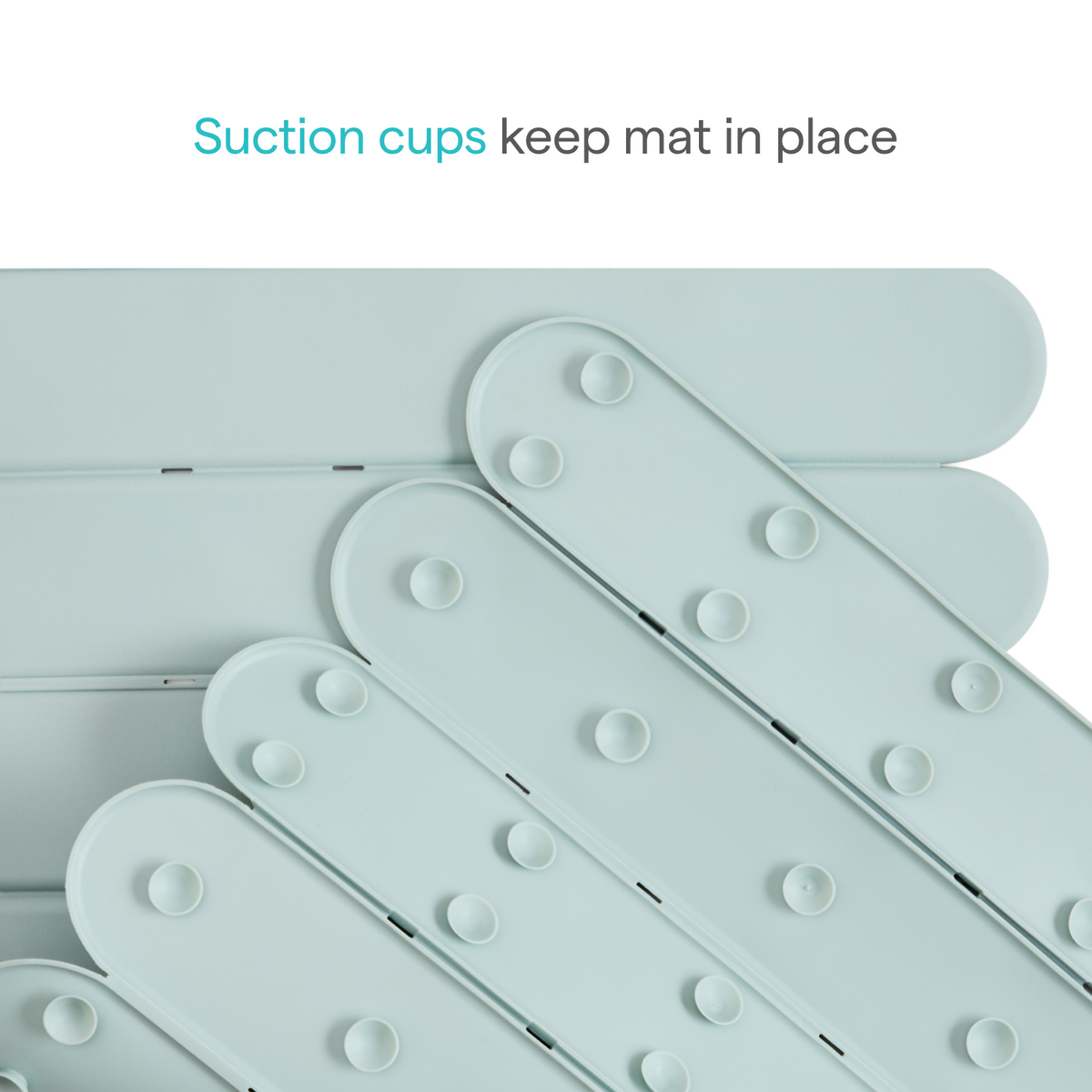 Close-up of pale mint silicone mat's rounded slats with raised suction cups, text: Suction cups keep mat in place